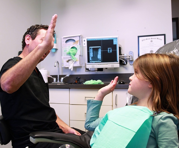 Upper Arlington childrens dentist giving a child a high five in dental chair