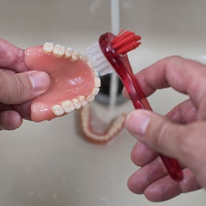 Dentures patient in Upper Arlington washing their prosthetic