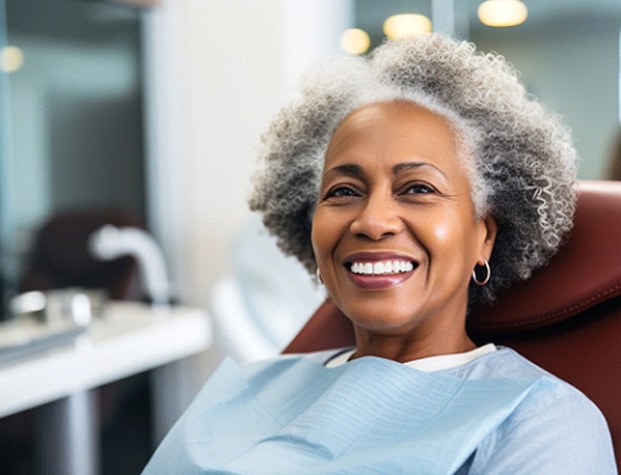 older woman smiling and sitting in the dental chair