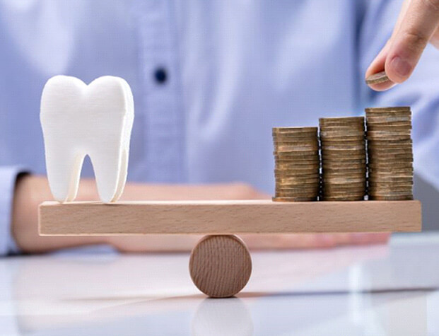 tooth model balanced against stack of coins