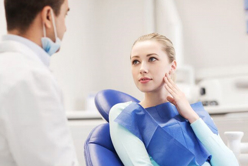 dental patient with toothache talking to dentist