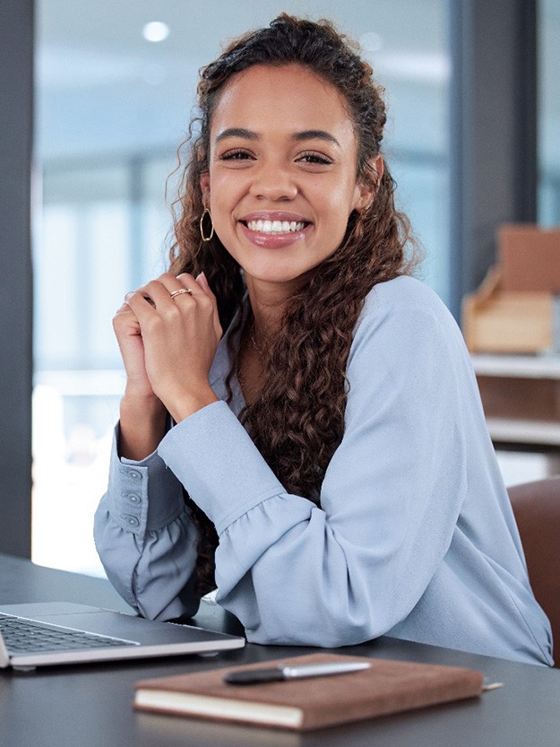 Smiling patient holding clear aligner