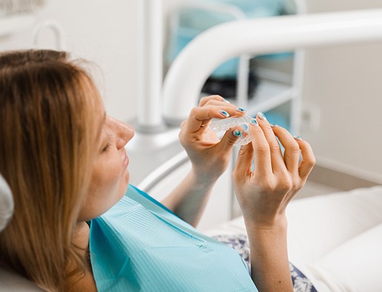 Clear aligner being placed on mold of teeth