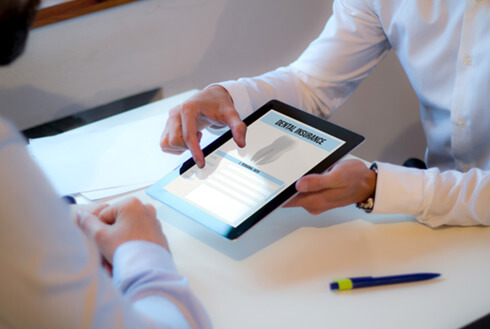 An insurance agent presenting a dental insurance form to a patient